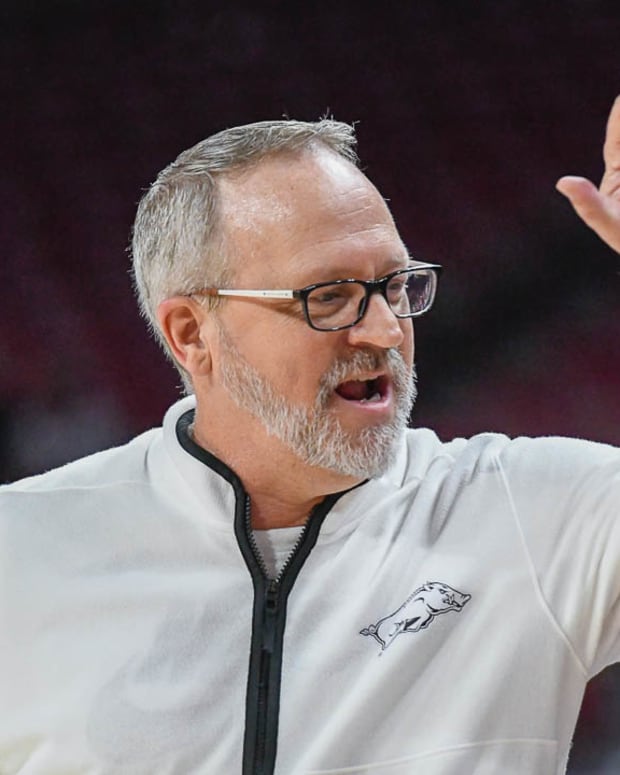 Razorbacks coach Mike Neighbors high-fives an assistant during 71-66 win over Texas Tech on Friday night.